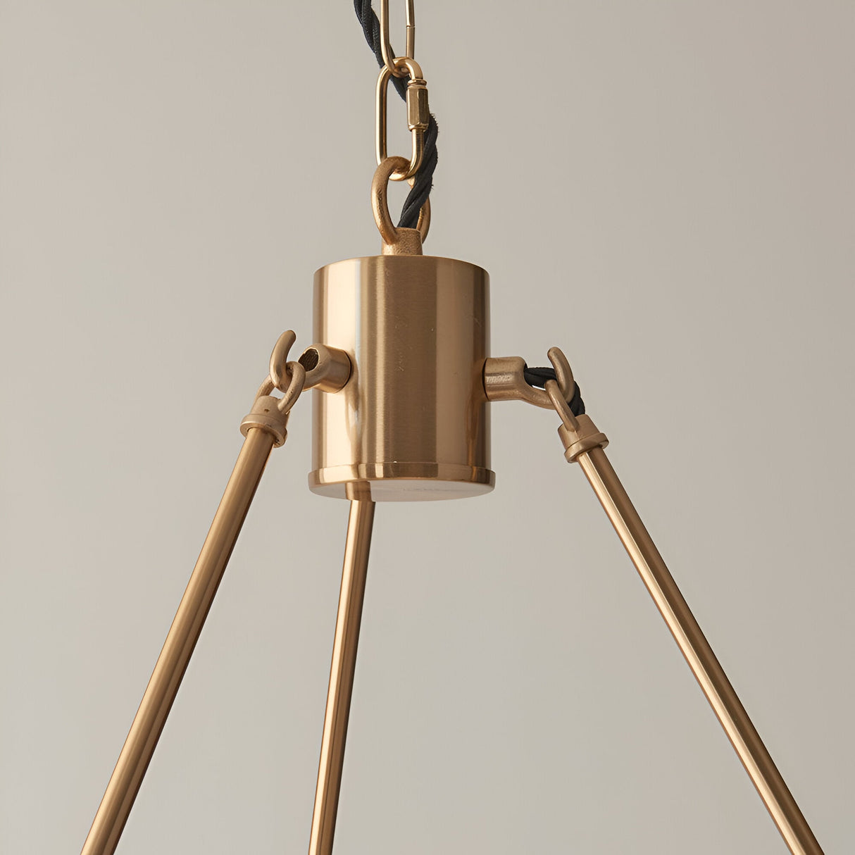 Close-up of the Endon Bevford 6 Light Pendant showing the aged brass cylindrical hub, black twisted fabric flex, chain suspension, and three visible arms.