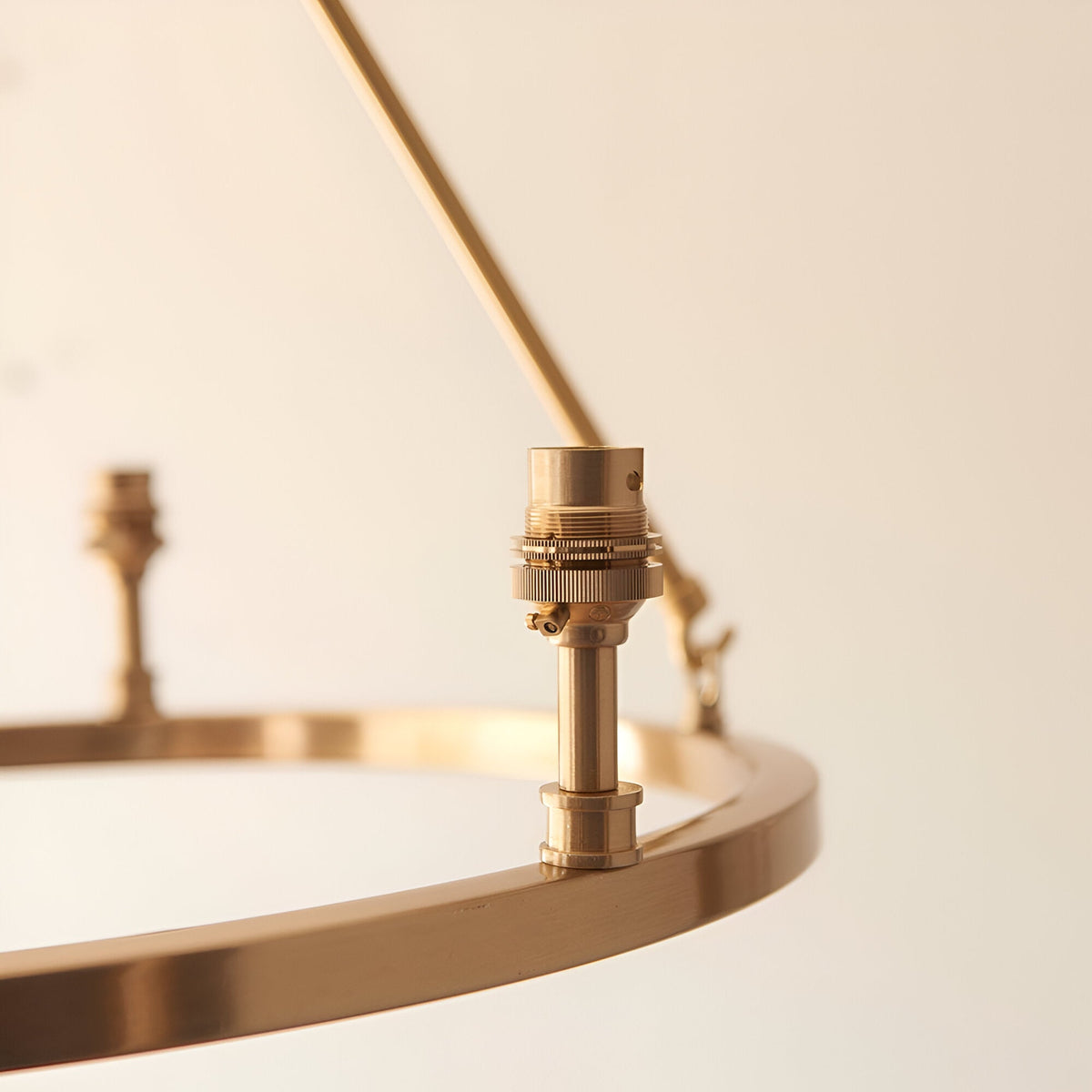Close-up of the Endon Bevford 3 Light Pendant showing an aged brass hoop with a B22 lamp holder mounted upright on the ring.