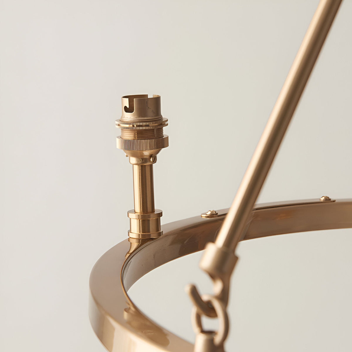 Close-up of the Endon Bevford 3 Light Pendant showing an aged brass B22 lamp holder mounted on the hoop frame with suspension rod and chain.