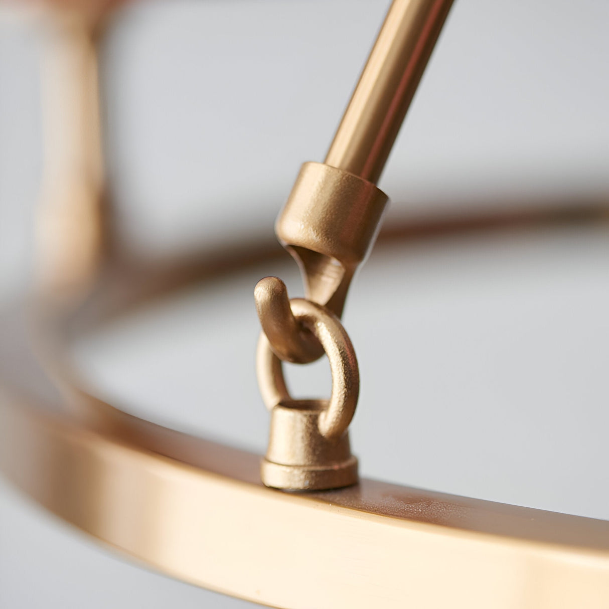 Close-up of Endon Bevford 3 Light Pendant showing the aged brass hoop, central rod and looped ring fitting in detail.