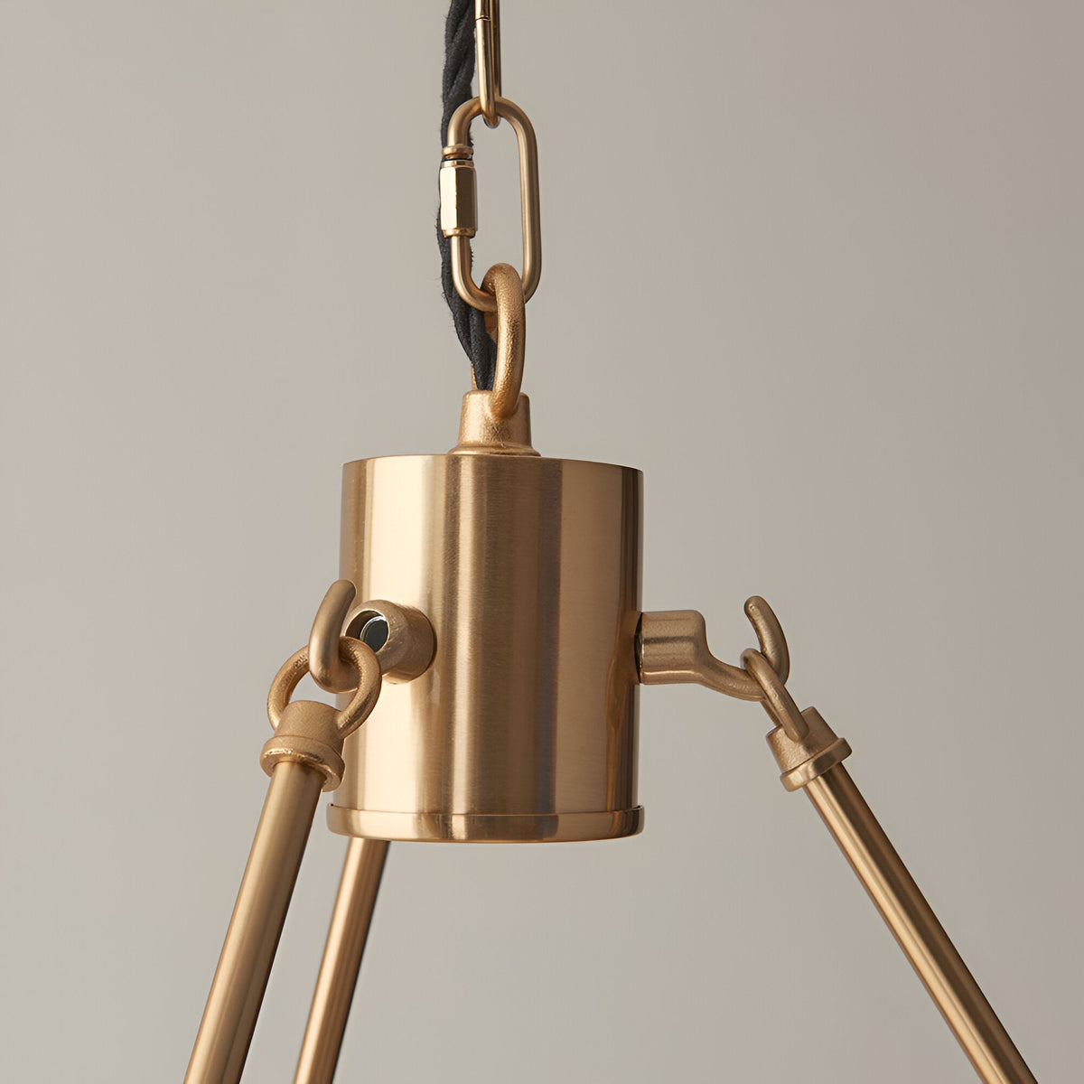 Close-up of the Endon Bevford 3 Light Pendant showing the aged brass cylindrical hub, chain suspension, and black twisted fabric flex.