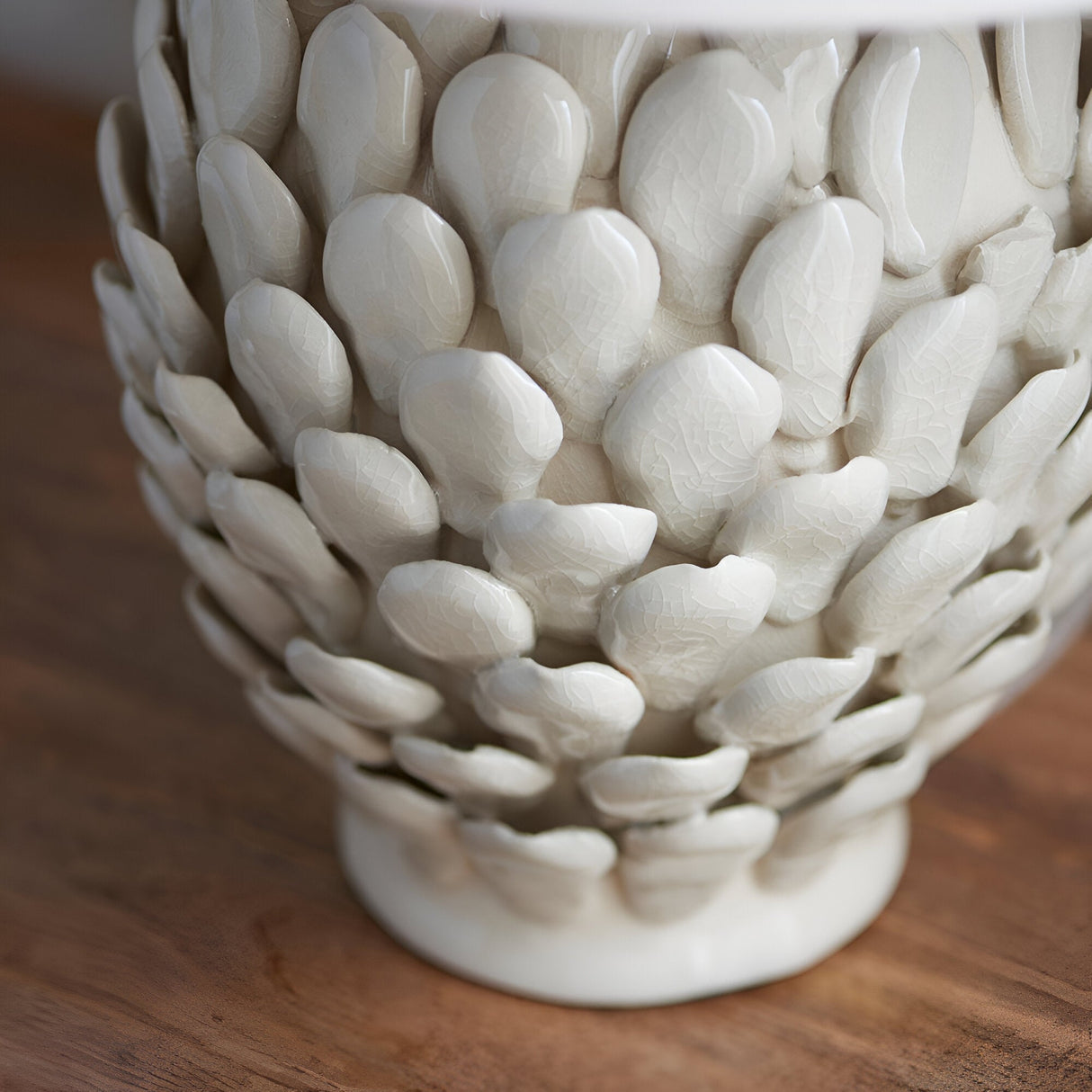 Caldford Small Table Lamp base in cream, ceramic with an ivory crackle glaze and layered leaf-shaped detailing, shown close-up on a wooden surface.