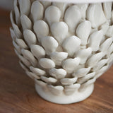 Caldford Small Table Lamp base in cream, ceramic with an ivory crackle glaze and layered leaf-shaped detailing, shown close-up on a wooden surface.