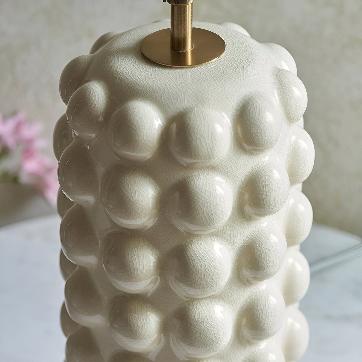 Amberley Table Lamp base in white ceramic with sculptured bobble texture and glossy glaze, aged brass stem and B22 lamp holder, close-up view.