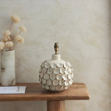 Endon Ashbury cream ceramic table lamp base with ivory crackle petal texture and aged brass B22 holder on a wooden console beside a dried flower vase.