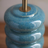 Cliffstead Table Lamp base close-up in ceramic with a blue ocean spray reactive glaze and stacked curved tiers, topped with a brushed brass fitting.