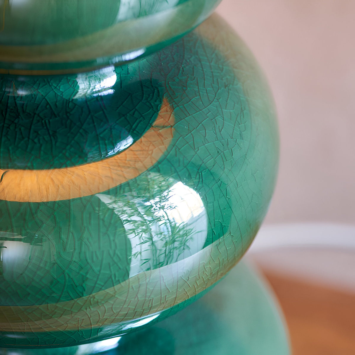 Close-up of the Endon Carlstead table lamp base showing its gourd-shaped ceramic form in a gloss green reactive glaze with subtle crackle detailing.