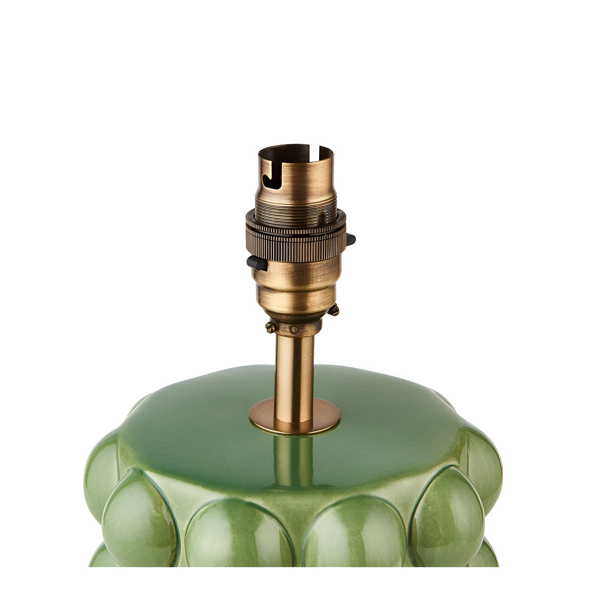 Close-up of the Endon Amberley table lamp's aged brass B22 lamp holder and stem mounted on the green ceramic bobble-textured base.