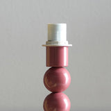 Endon Brenleigh table lamp base in gloss pink, showing the stacked metal sphere and E14 lampholder detail against a light grey background.