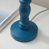 Close-up of the Endon Aldworth table lamp base in marlin blue turned wood with grey braided flex, beside a magazine on a white surface.