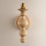 Endon Aldworth wall light in natural ash with turned spindle body and brass B22 lampholder, shown shadeless against a plain neutral wall.