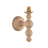 Endon Aldworth wall light in turned natural ash with visible wood grain, brass B22 lampholder, and round wall plate, shown on a plain white background.