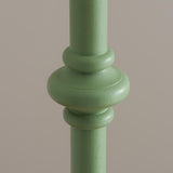 Close-up of the Endon Bevbury floor lamp's turned wooden spindle detail in Cotswold green satin paint against a neutral background.