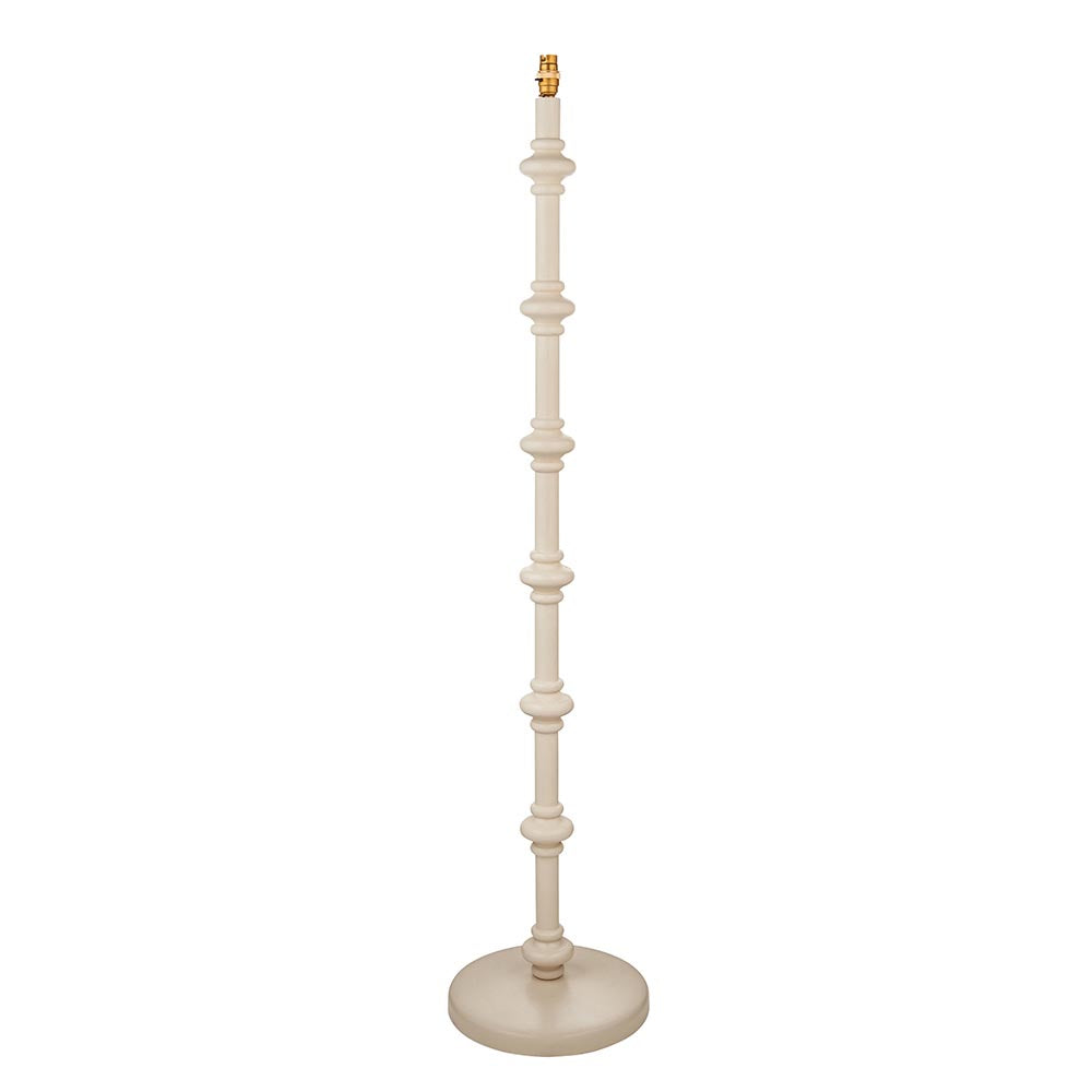 Endon Bevbury floor lamp with a turned wooden spindle base in almond white, brass B22 lamp holder and round base, shown on a plain white background.