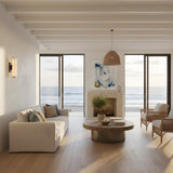 Modern living room with large windows overlooking the ocean, neutral furnishings like a white sofa and wooden coffee table, and Selvara LED Small Alabaster Double Wall Light in matte black & soft white providing gentle illumination as natural light fills the space.