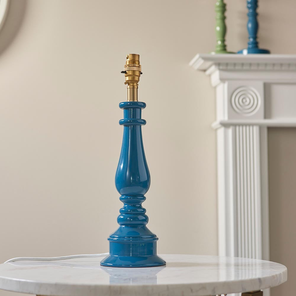 Endon Carlworth table lamp base in gloss Marlin Blue turned spindle resin with brass B22 holder, displayed on a marble side table by a white fireplace.