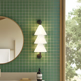 Boga LED Cone Glass Linear Wall Light in matt black with three stacked white glass cone shades, illuminated on a green tiled bathroom wall beside a round mirror.