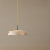 Bonn Alabaster Drum Pendant Light with a shallow, tapered veined alabaster shade on a metallic blue stem and cream textile cable, shown against a plain neutral background.