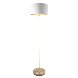 Endon Brenley floor lamp with brass stand, white drum shade and gold metallic inner, lit E27 fitting, on a plain white background.