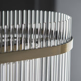 Close-up of the Beaumont 4 Light Linear Pendant, showing clear glass rods lined along an antique brass bar for a decorative diffused glow.