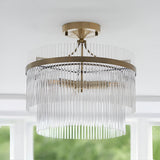 Endon Beaumont 3 light semi-flush ceiling light in brass with two tiered rings of clear glass rods, mounted to a white ceiling near a window.