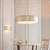 Rosaline 5 Light Pendant in nickel and white, a large drum shade with geometric fretwork outer and frosted glass diffuser, hung above a dining table.