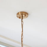 Close-up of the Endon Brenbury pendant ceiling rose in brushed brass with a twisted grey fabric cable feeding into a linked brass chain.