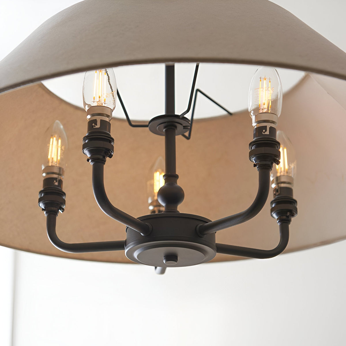 Close-up of the Endon Caldmere 5 Light Pendant showing the matt black round frame, five B22 candle bulbs, and interior of the natural linen shade.