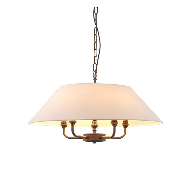 Endon Caldmere 5 light pendant with a wide tapered natural linen shade on antique brass arms, suspended from a black chain against a white background.