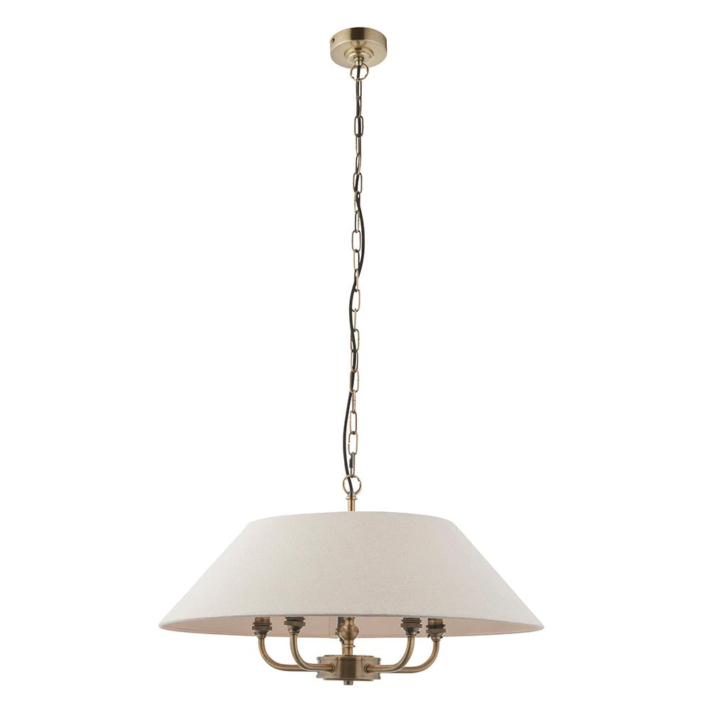 Caldmere 5-light pendant with a wide natural fabric drum shade over a brass five-arm frame, hung from a brass chain on a plain white background.