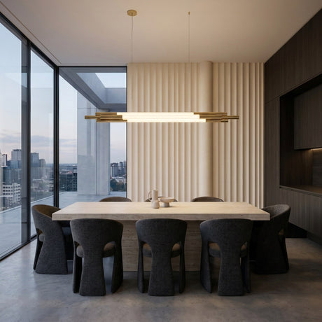 A modern dining room features a large, light-toned rectangular table with eight sculptural chairs, a unique centerpiece, gold & white accents, textured wall panels, and cityscape views illuminated by the Org LED Linear Suspension Light in Gold & White.