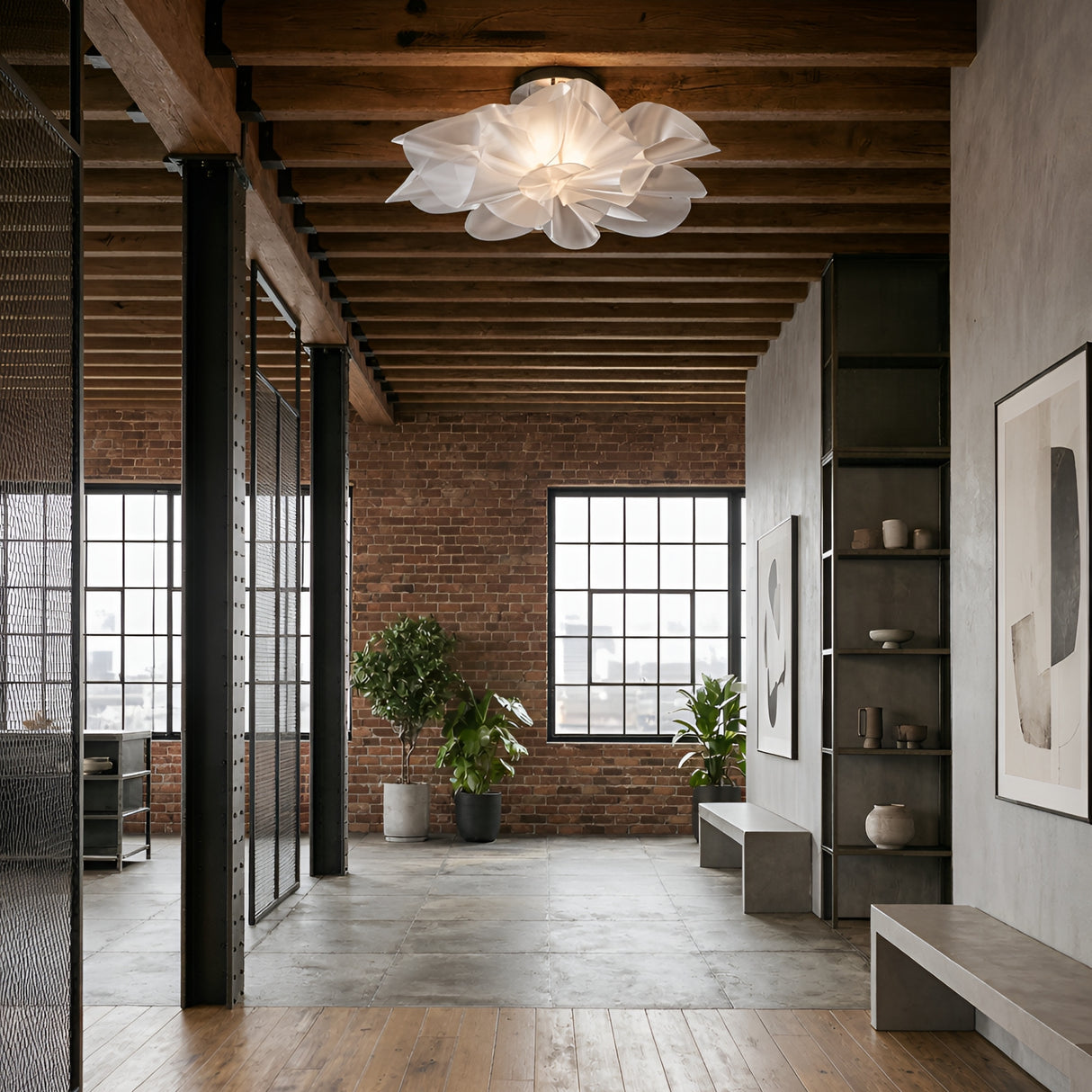 Modern industrial loft with exposed brick walls, grid windows, wood ceiling beams, concrete floor, minimalist furniture, plants, abstract art, and a striking sculptural fixture featuring the Violla LED Flush Ceiling Light - White.