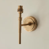 Endon Bevford wall light in aged brass, compact fitting with a slim stem, B22 lampholder and round wall plate, shown against a pale background.