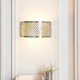 Endon Rosaline 2 light wall light in satin nickel with geometric fretwork and white inner shade, illuminated on a panelled wall above a vase of flowers.