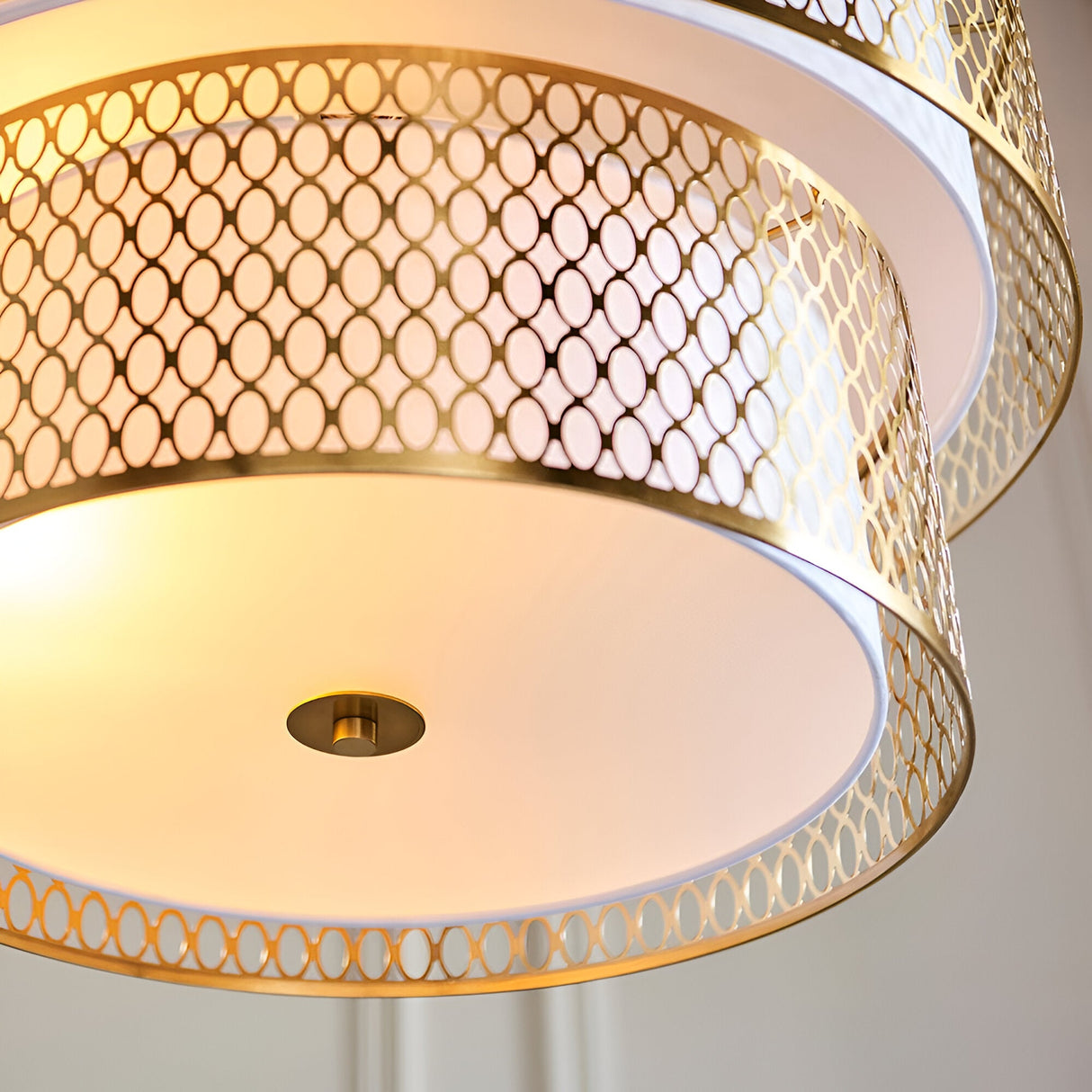 Close-up of Endon Rosaline 6 Light Chandelier in gold, showing tiered circular fretwork bands, white fabric inner shade and frosted glass diffuser.