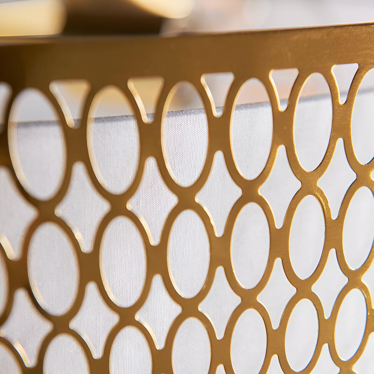 Close-up of the Rosaline 5 Light Pendant in gold, showing geometric metal fretwork with an oval and diamond pattern over a white fabric inner shade.