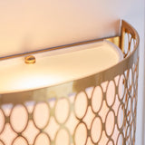 Close-up of the Rosaline 2 Light Wall Light in gold, showing curved geometric fretwork, white fabric inner shade, and frosted glass diffuser detail.