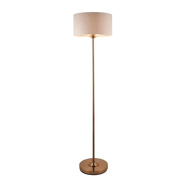 Brenley Floor Lamp in brass with slim tall stem, round base, and drum-shaped fabric shade, shown on a plain white background.