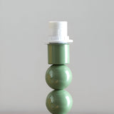 Endon Brenleigh table lamp base in glossy green with stacked metal spheres and white E14 lampholder, shown close-up against a plain light background.
