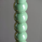 Close-up of the Endon Brenleigh table lamp base showing stacked glossy green metal spheres against a soft grey background.
