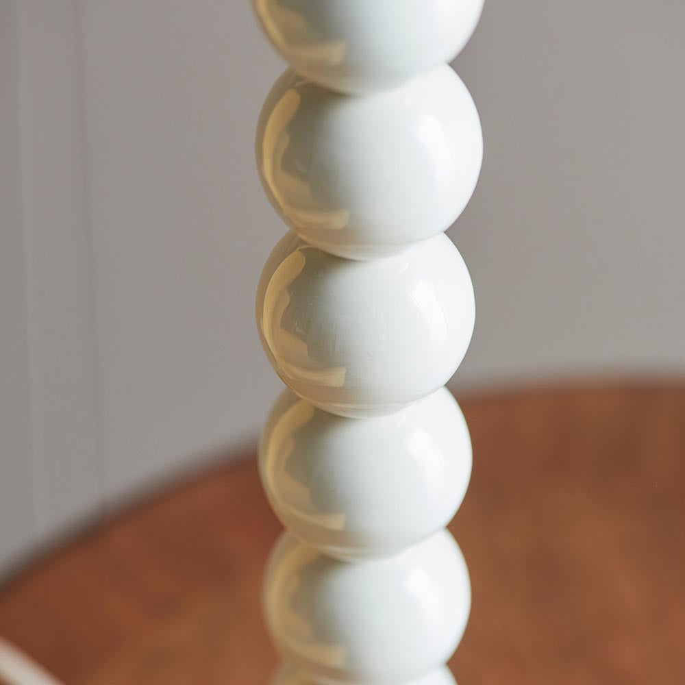 Close-up of the Endon Brenleigh table lamp base showing stacked glossy white metal spheres against a soft neutral background.
