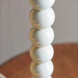 Close-up of the Endon Brenleigh table lamp base showing stacked glossy white metal spheres against a soft neutral background.
