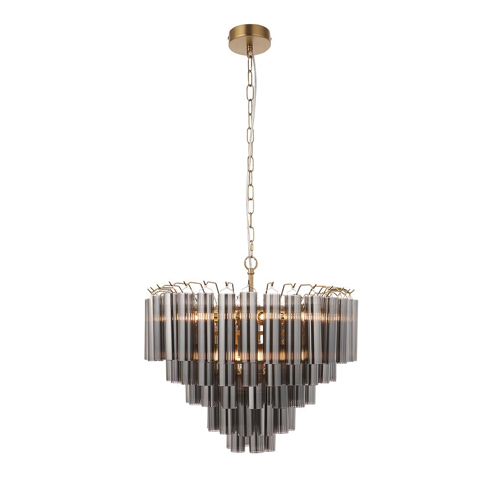 Endon Cranshaw 12 light tiered pendant with smokey grey glass tubes on a satin brass frame, hung from a chain ceiling fixing on a white background.