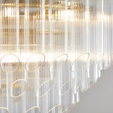 Close-up of the Cranshaw 12 Light Tiered Pendant in brass, showing clear ribbed glass rods and satin brass rings arranged in layered tiers.