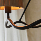 Close-up of the Endon Danemont 3 Light Pendant in black, showing the matt black wave-shaped hoop and one hand-wrapped raffia tapered shade.