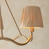 Danemont 3 Light Pendant in brass, close-up of a wave-shaped hoop arm holding a pleated cream fabric shade, against a plain neutral background.