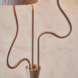 Close-up of the Danemont 3 Light Floor Lamp's wriggle stem in brushed aged brass, showing three curved metal arms meeting at a tapered base.