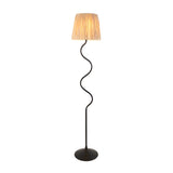 Endon Danemont floor lamp with a wriggle-shaped matt black metal stem and tapered hand-wrapped natural raffia shade, shown on a white background.