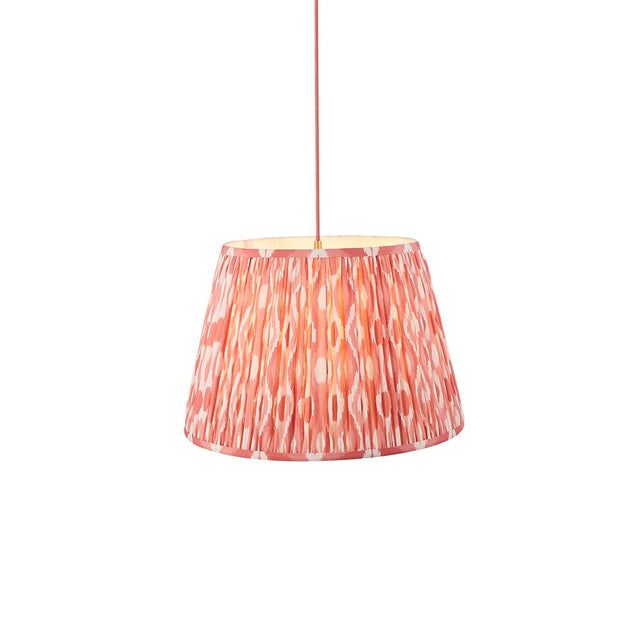 Endon Brackmont Ikat Coral pendant light with a handmade pleated tapered faux silk shade in pink and red, on a red braided cable, against a white background.