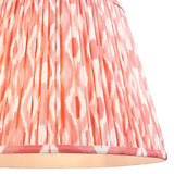 Close-up of the Endon Brackmont Ikat Coral pendant shade, showing hand-pleated faux silk in a coral pink and white Ikat print with taped edge trim.